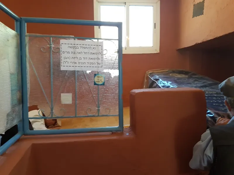פנים הציון — קברו של רבי דוד ומשה מוקף בנרות ופרחים